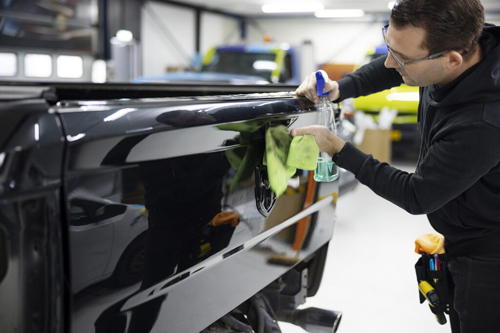 hombre de tiro medio limpiando auto